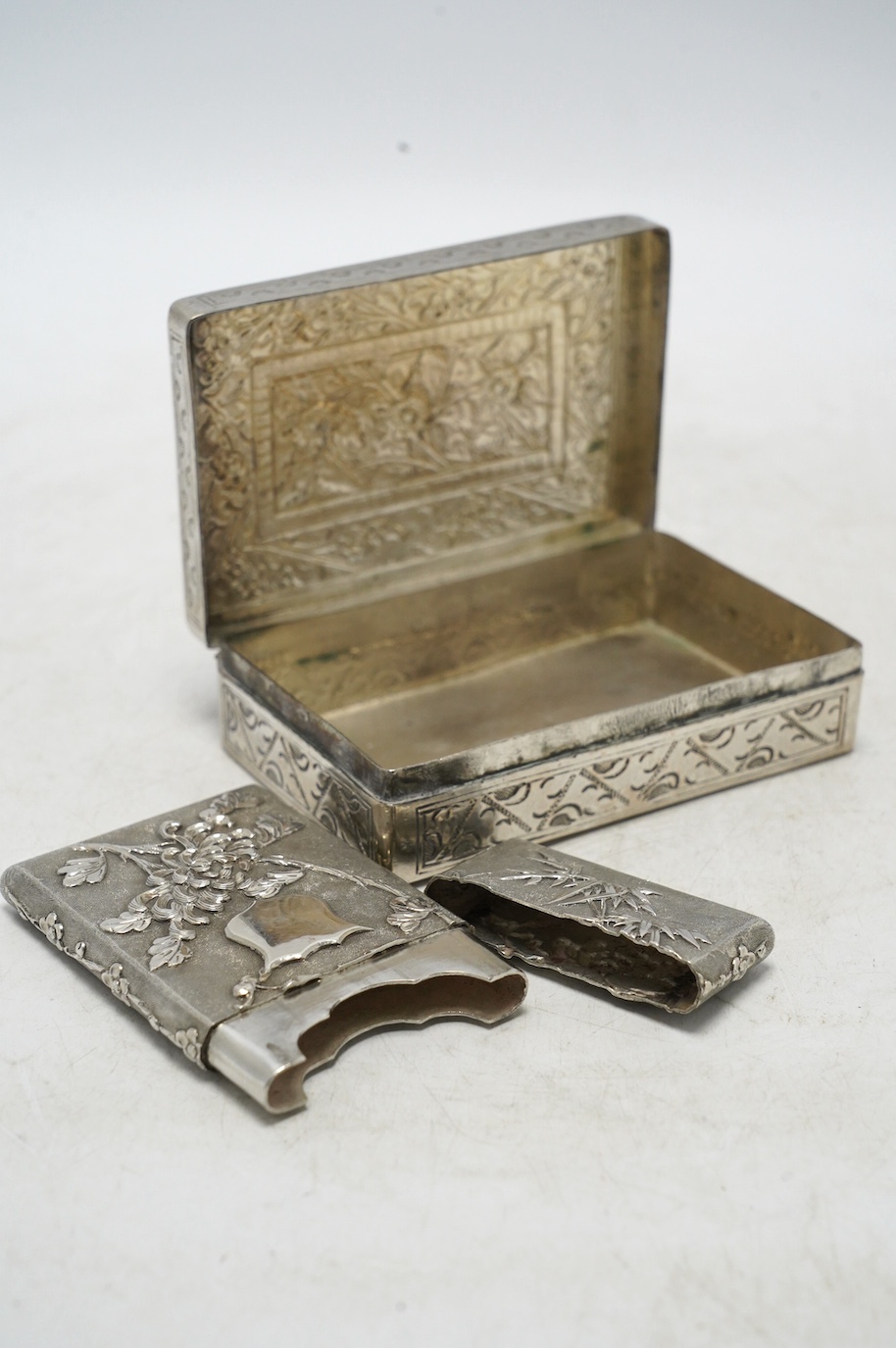 An early 20th century Chinese Export white metal card case by Wang Hing, 84mm, together with a Chinese white metal box with hinged cover. Condition - fair to good